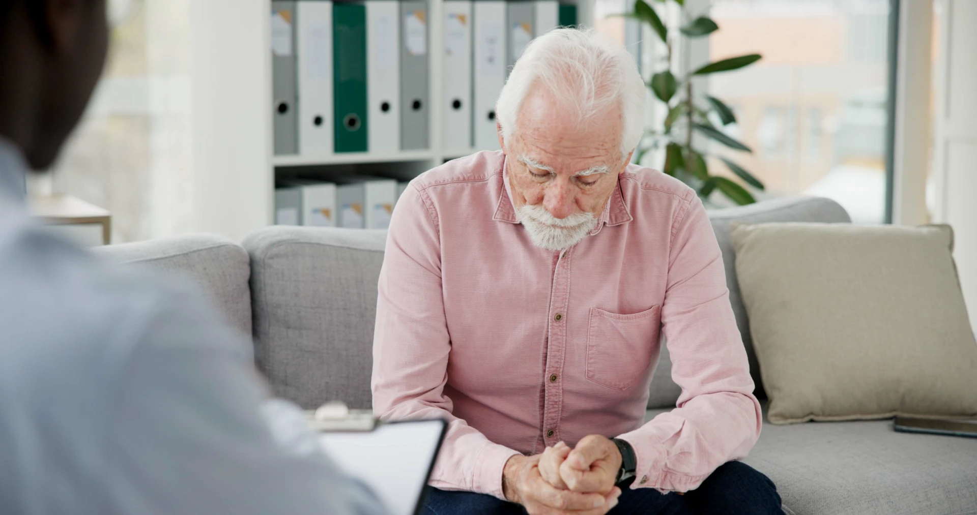 senior-man-sitting-on-couch-talking-with-doctor