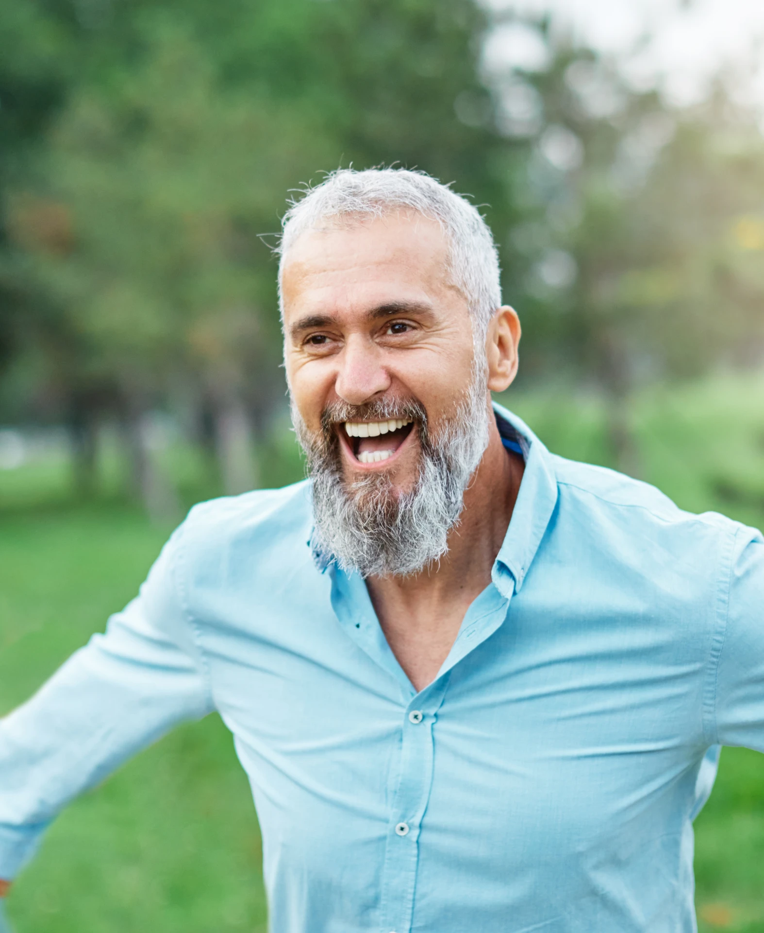 joyful-senior-man-with-gray-beard-laughing-outdoors